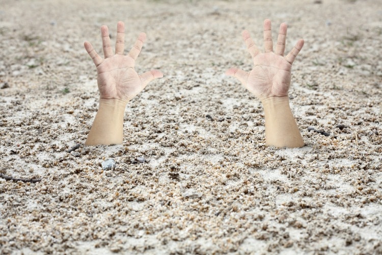 Hands sticking out of quicksand caused by a bad sale