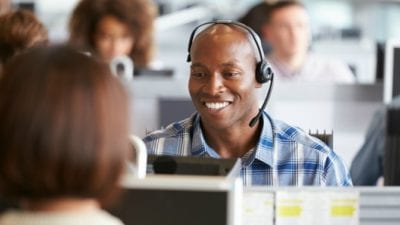Man talking on phone at computer in call center