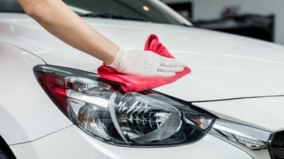 gloved hand cleaning car