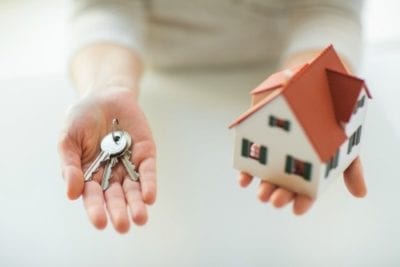 hand holding keys and a house