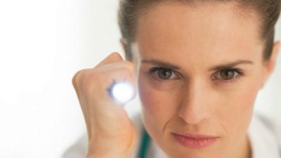 woman shines flash light on nagging and nit-picky issues