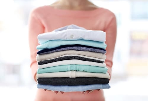 woman with a stack of folded laundry
