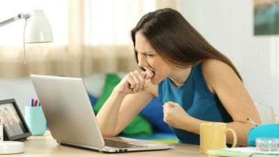 woman working from home on computer upset house cleaner is late