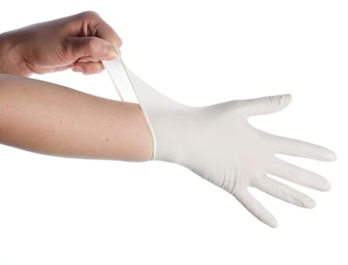 Hand putting on white disposable gloves