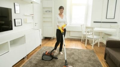 Party help - woman cleaning living room