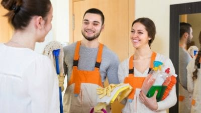Happy house cleaners with homeowner, not texting