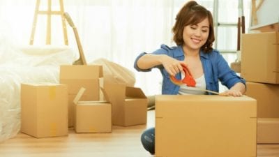 Woman packs moving boxes