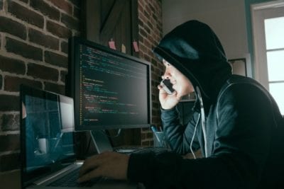 Scams Targeting House Cleaners, Sketchy Guy in Hoodie With Computer on Cell Phone