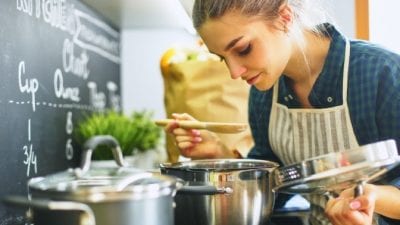 Airbnb cleaning fee, woman cooking in kitchen