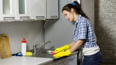 How To Speed Up Slow Maids woman cleaning countertop with sponge