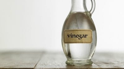 Cruelty-Free Cleaning Products jar of vinegar on wooden counter