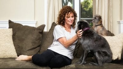 How Much to Clean 5 Rooms woman sitting on couch with dogs