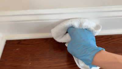How to Clean Baseboards, gloved hand with terry cloth