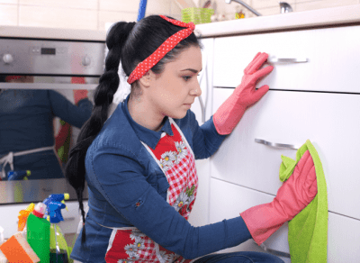 Base Rate or Charge More for a Deep Clean, Woman Cleaning Kitchen Cabinet