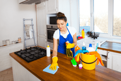 Base Rate or Charge More for a Deep Clean, Woman Wiping Kitchen Island