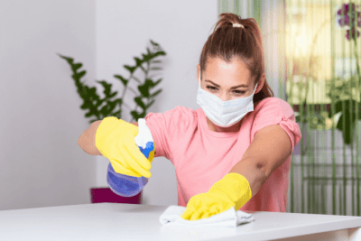 How to Start a Cleaning Business After COVID, House Cleaner Wiping Counter Wearing Mask