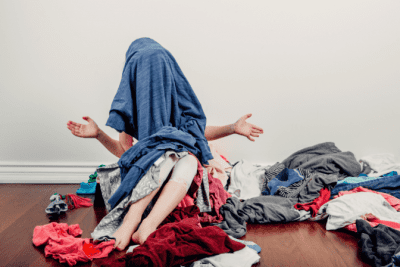 The Risk of The Big Pile, Woman in Pile of Clothes on Floor