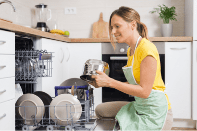 Dishes in the Kitchen Sink, Woman Loading Dishes in Dishwasher