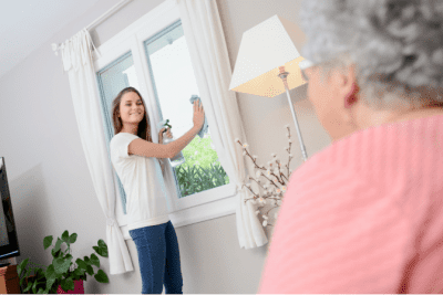 Why Do Clients Hover and Follow You Around, Woman Talking to House Cleaner Cleaning Glass