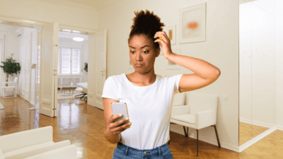 Smartphone Ready, Confused Woman Looks at Phone